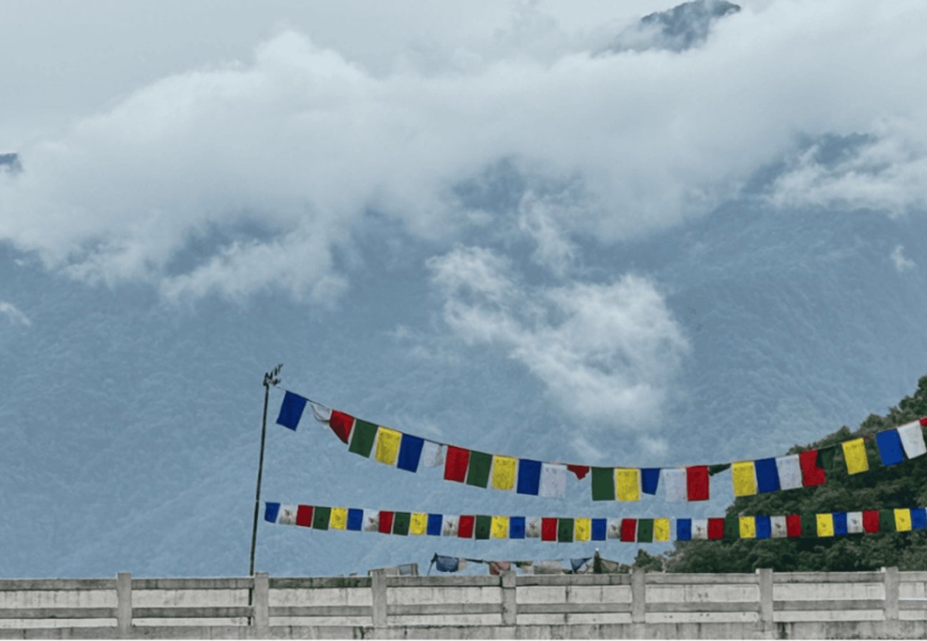 Colorful Buddhist prayer flags fluttering against misty Himalayan mountains in Bhutan