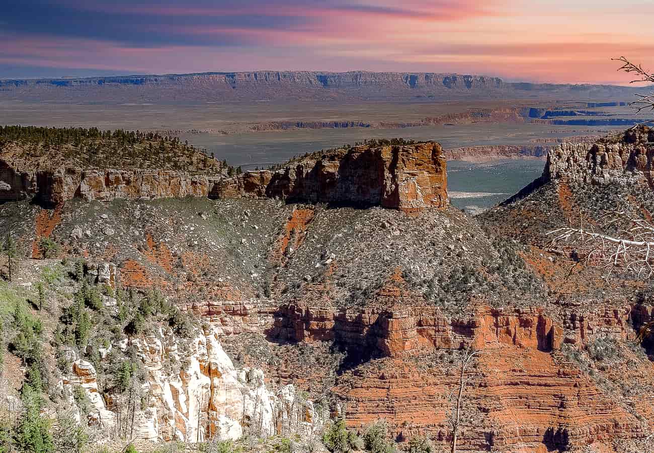 Expansive panoramic view overlooking deep forested canyons and crimson cliffs from Point Imperial on the Grand Canyon North Rim