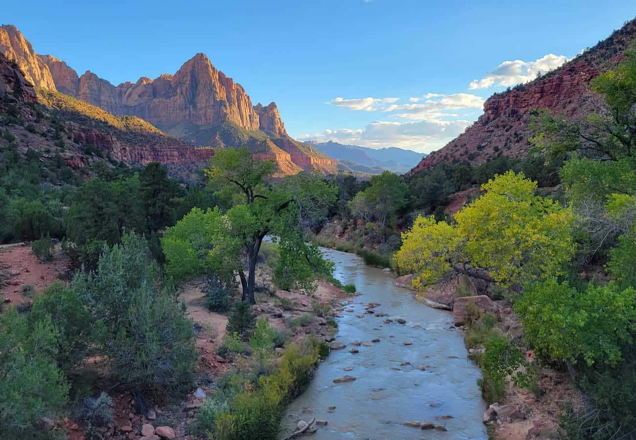 Dramatic view of The Watchman rock formation towering above the Virgin River at sunset in Zion National Park Utah