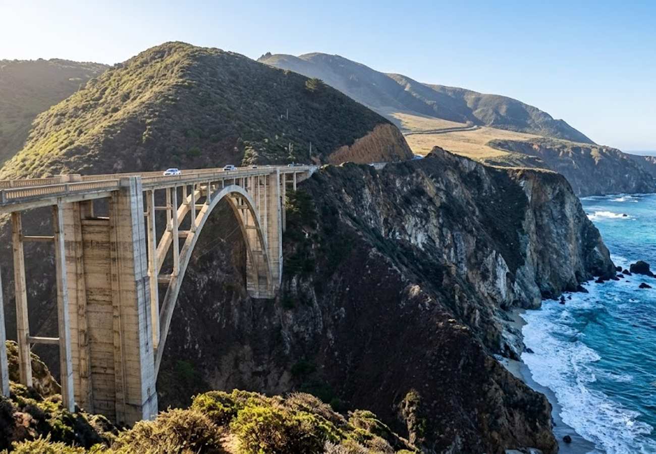 Iconic Bixby Creek Bridge soaring across a deep coastal canyon on California Highway 1 against crashing Pacific surf