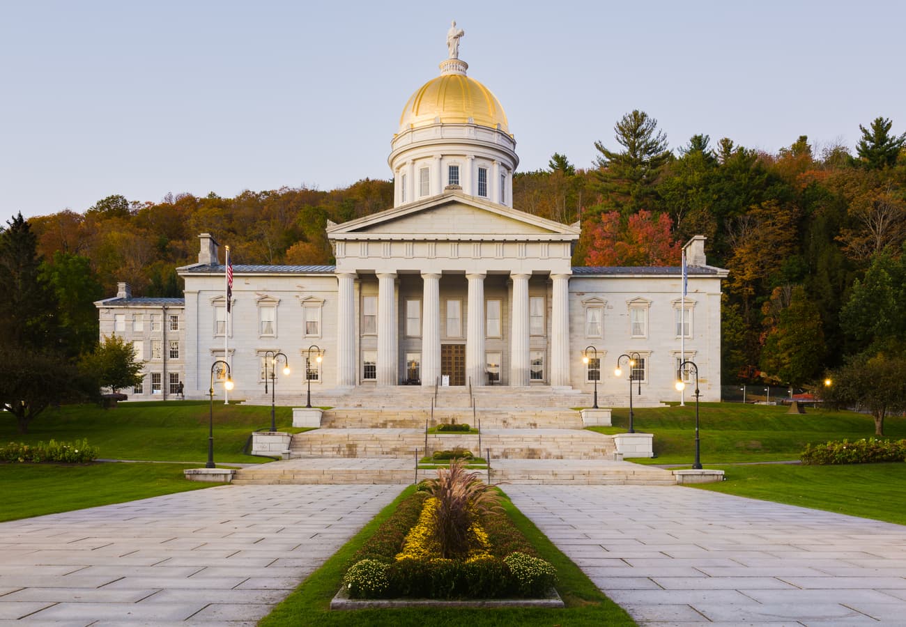 The golden dome of the Vermont State House framed by autumn trees in Montpelier