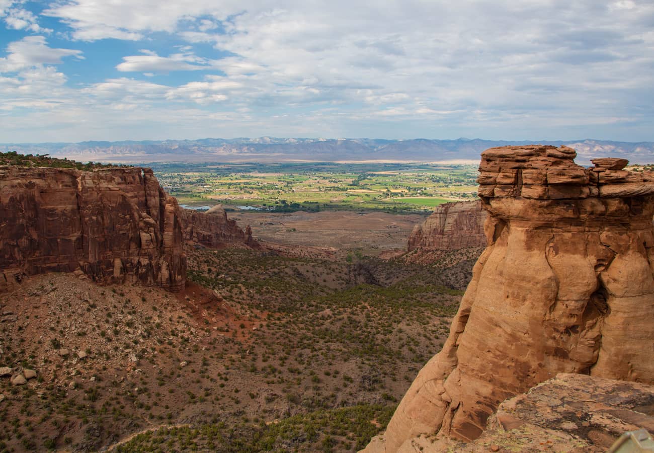 Panoramic view of red sandstone canyon cliffs from Rim Rock Drive in Colorado National Monument