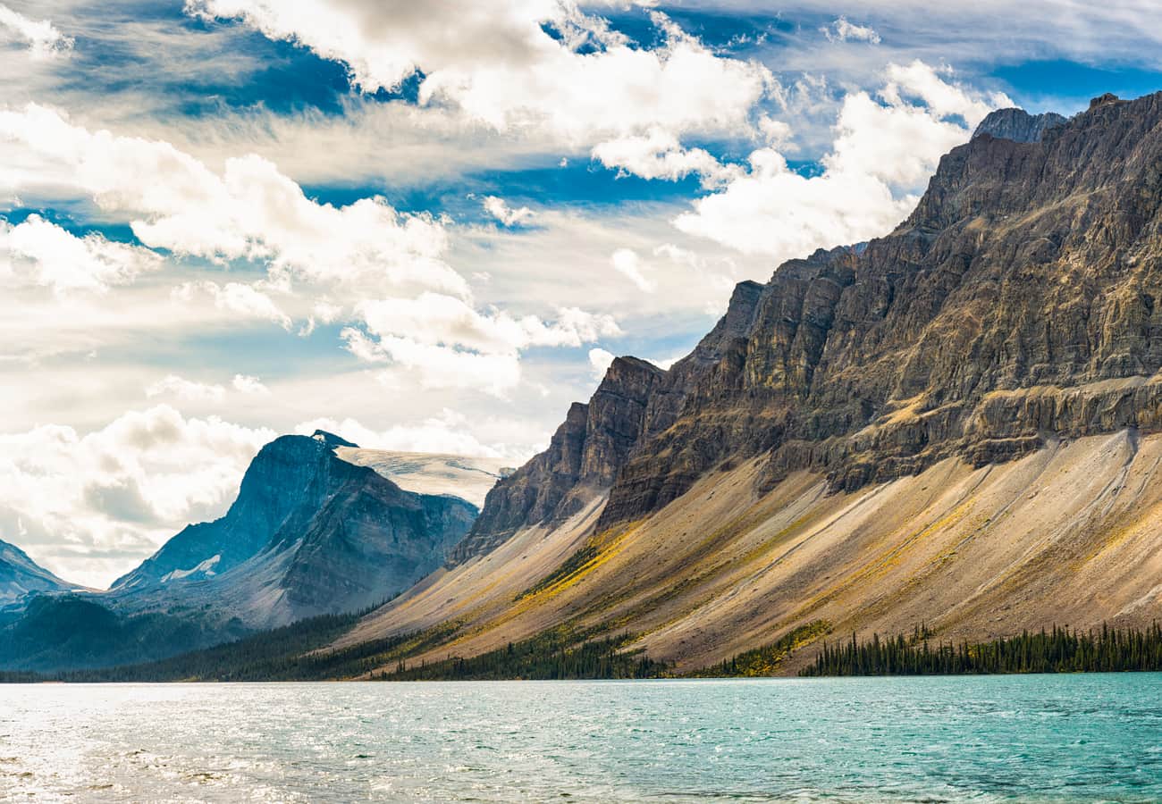 Serene morning reflections of Crowfoot Mountain across the crystal-clear waters of Bow Lake