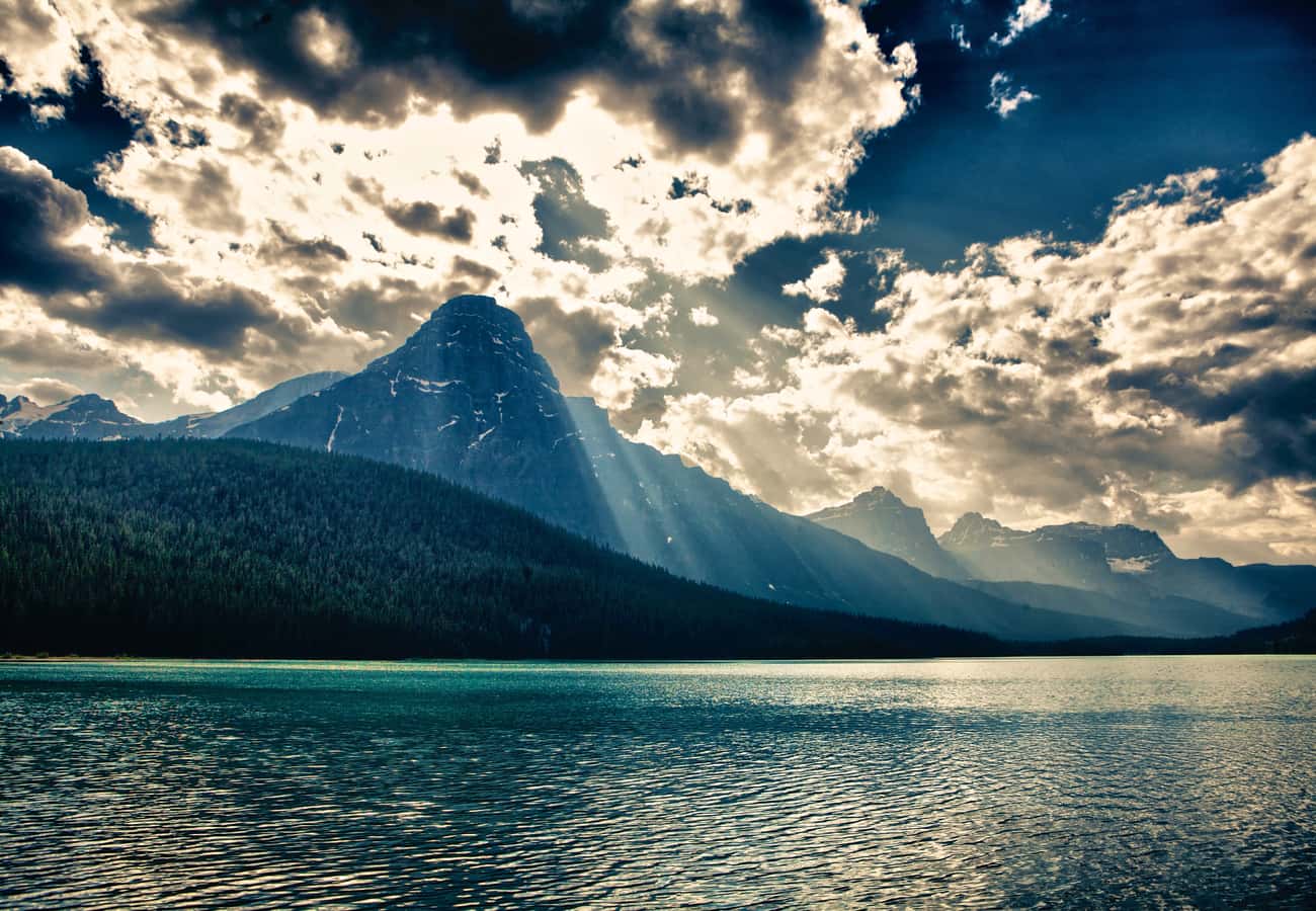 Dramatic sun rays illuminating the towering pyramid peak of Mount Chephren above Waterfowl Lake