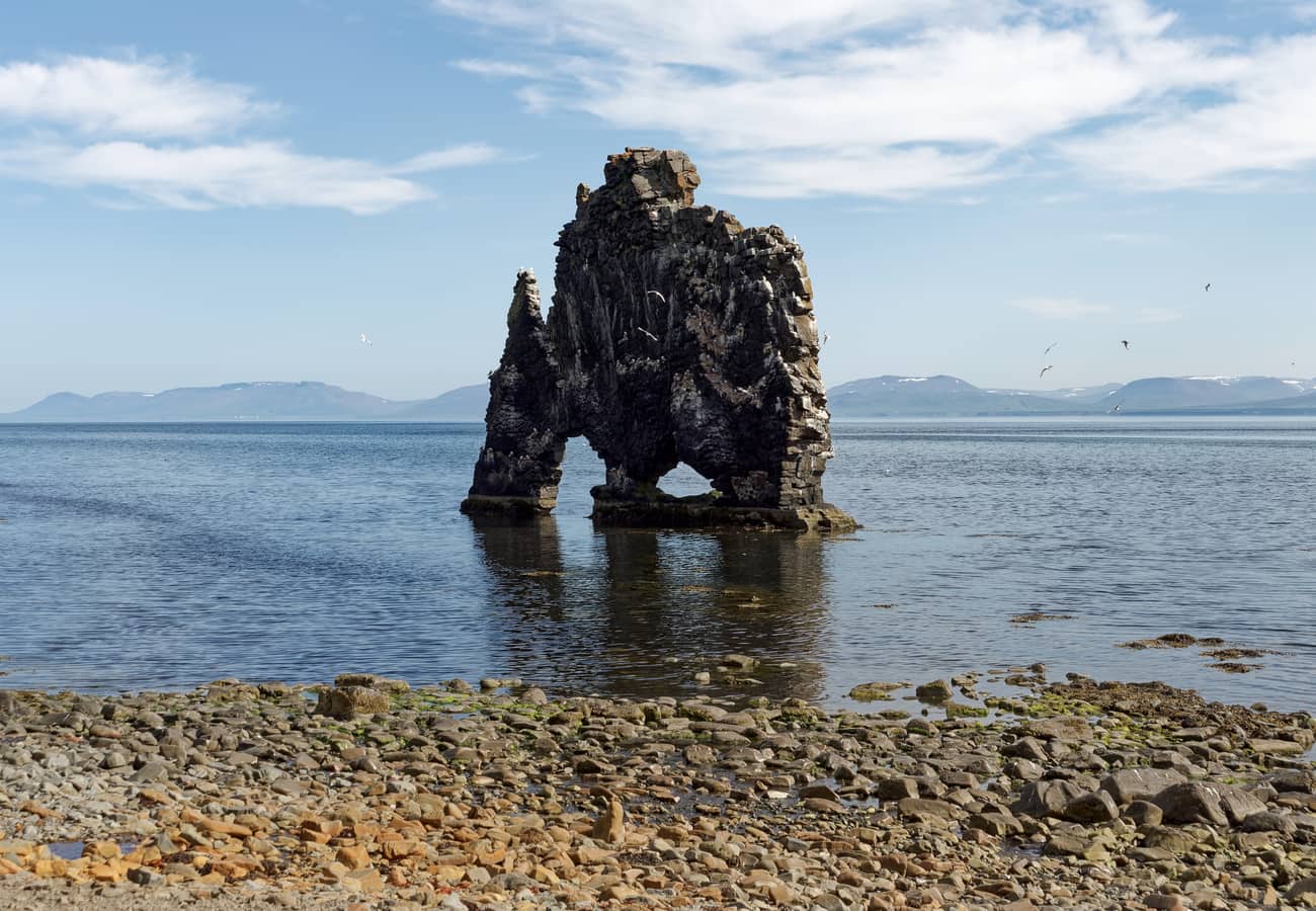 Basalt sea stack of Hvítserkur standing tall in ocean surf off North Iceland
