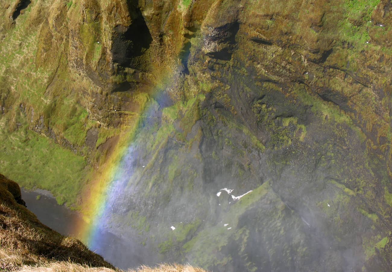 Massive wall of falling water and vibrant double rainbow at Skógafoss