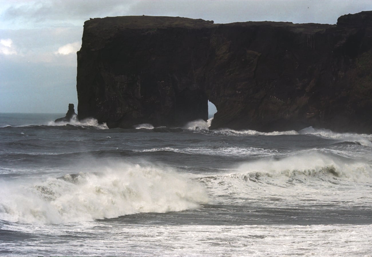 High coastal promontory and natural rock arch at Dyrhólaey near Vík