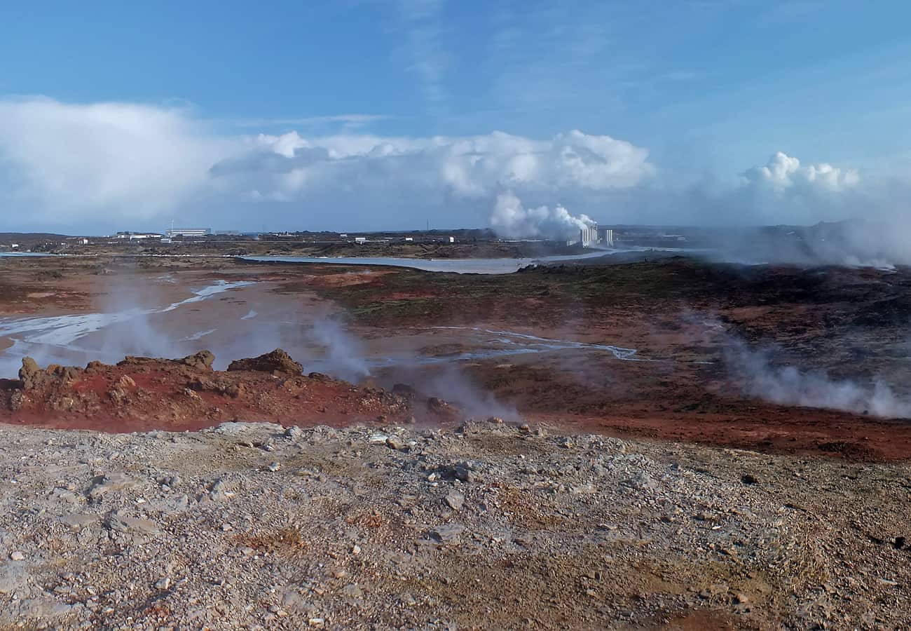 Panoramic view of steaming geothermal vents and turquoise mineral springs at Gunnuhver