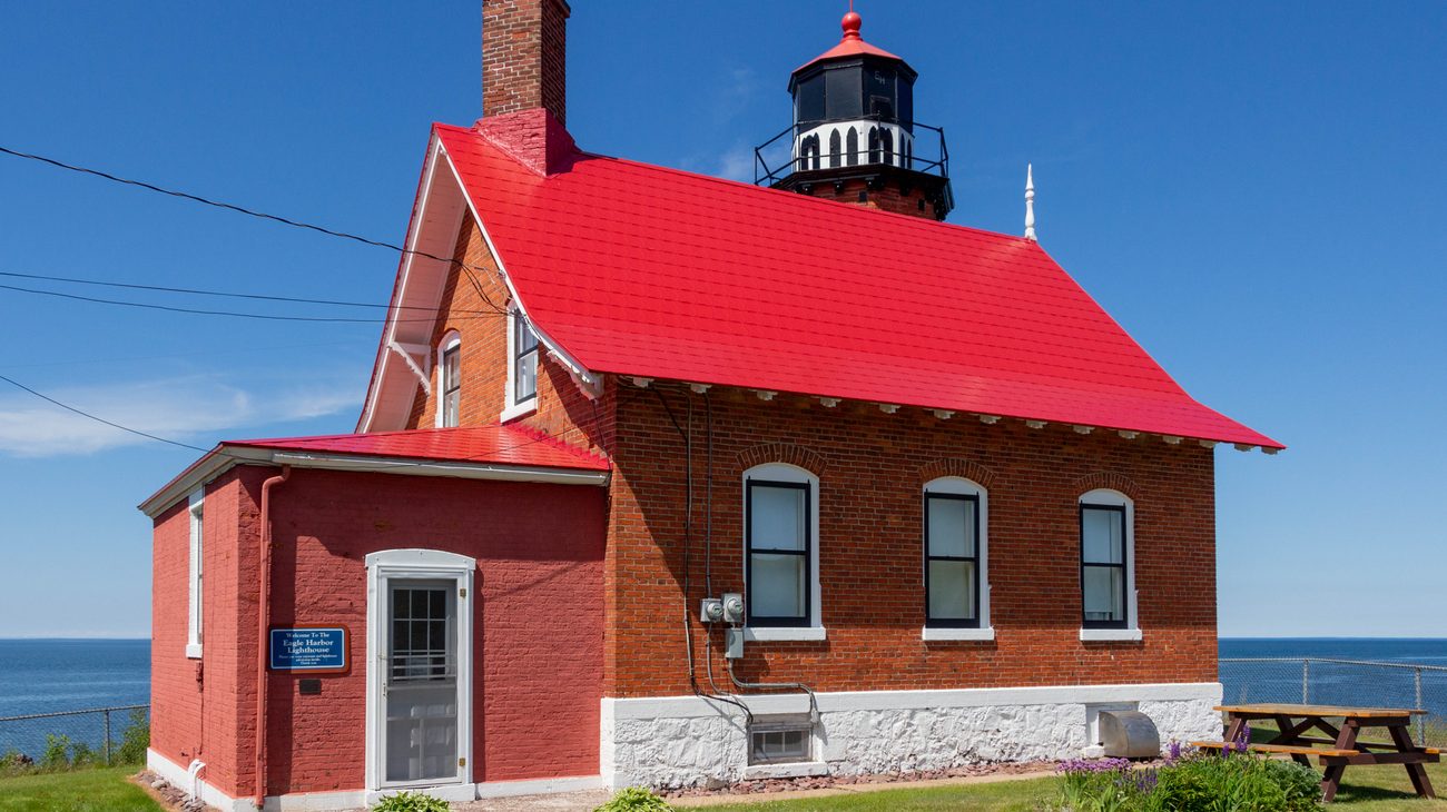 Historic Eagle Harbor Lighthouse with octagonal brick tower perched above Lake Superior rocky bluffs