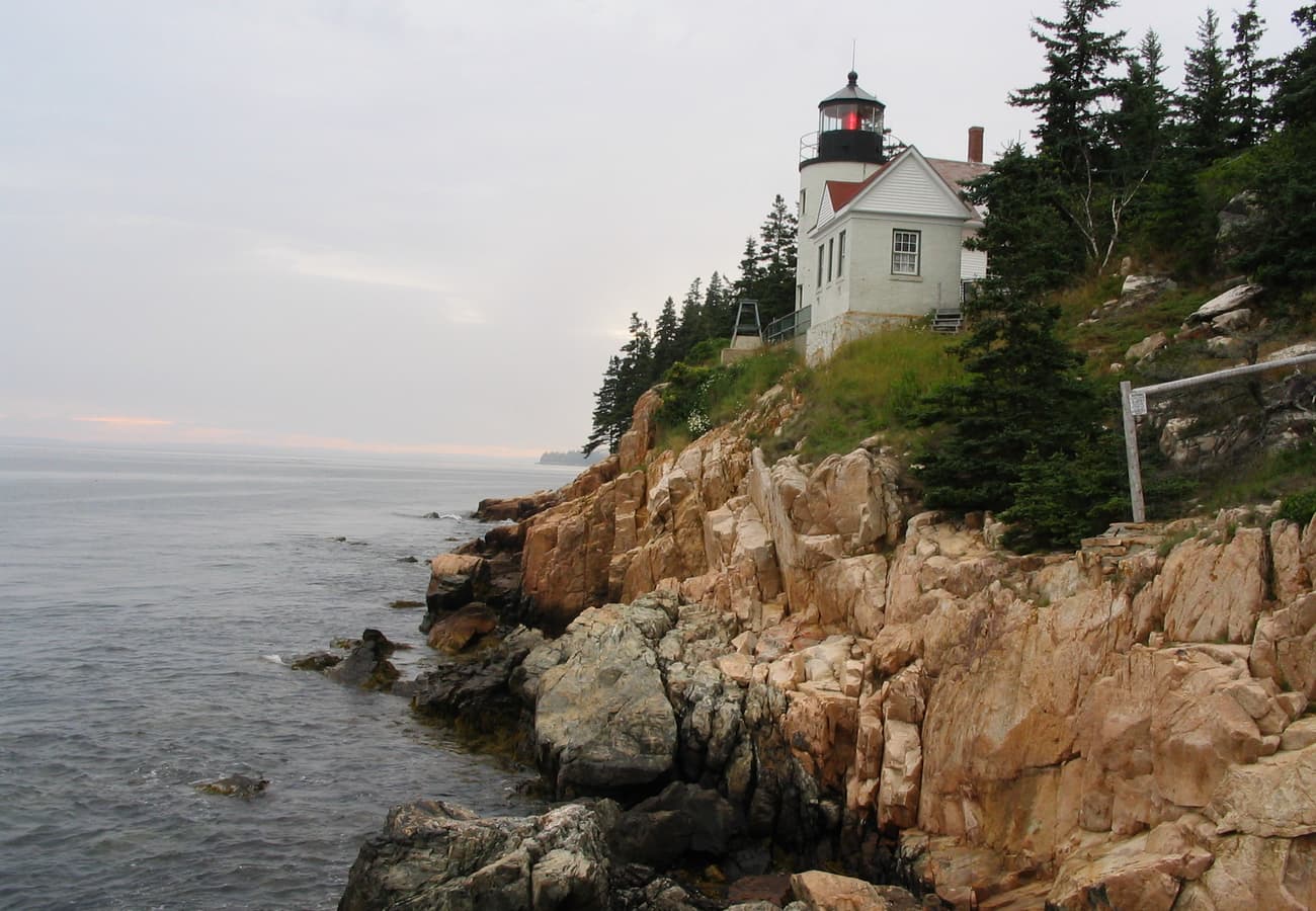 Historic Bass Harbor Head Lighthouse perched on rocky granite ocean cliffs