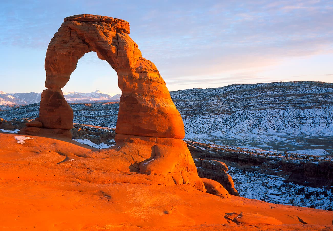 Iconic Delicate Arch framing the distant La Sal Mountains in Utah