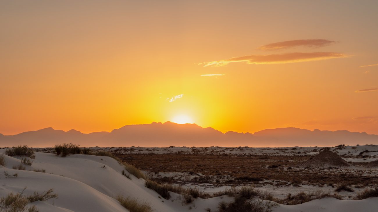 Surreal white gypsum dunes of White Sands National Park glowing under sunset in New Mexico