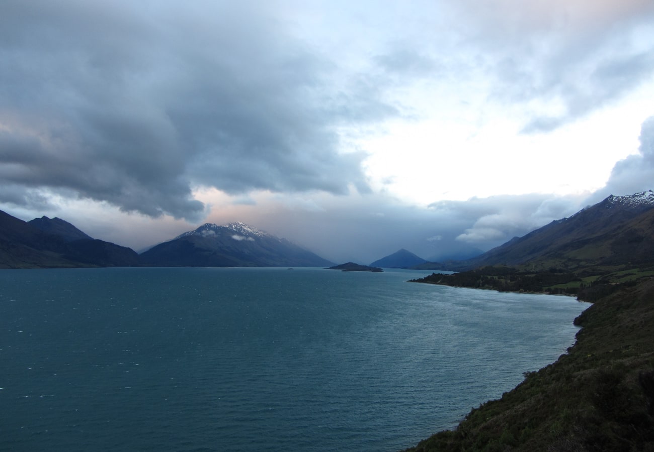 Dramatic alpine mountain silhouettes reflected across Lake Wakatipu