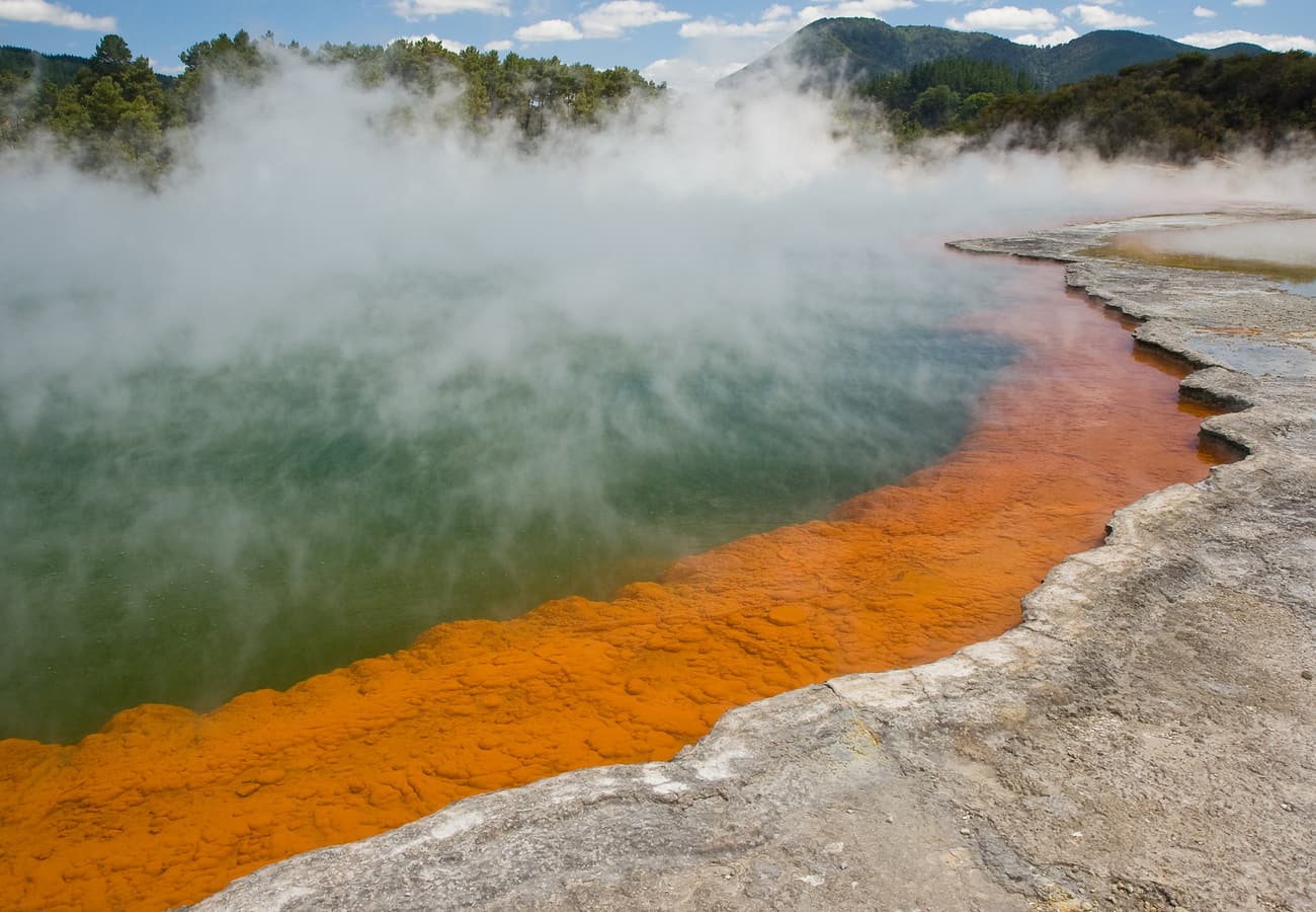 Champagne Pool mineral hot spring steaming with orange sinter edges in Wai-O-Tapu