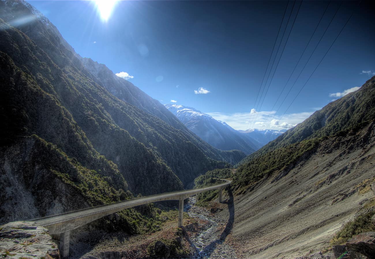Historic stone church and forested mountain slopes in Arthur's Pass