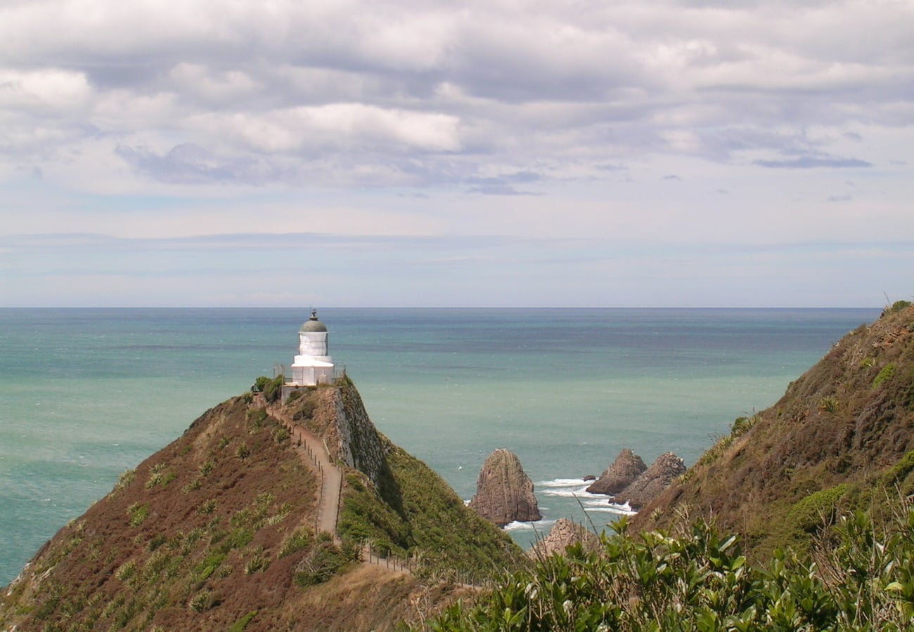 Windswept Nugget Point Lighthouse perched on high ocean cliffs