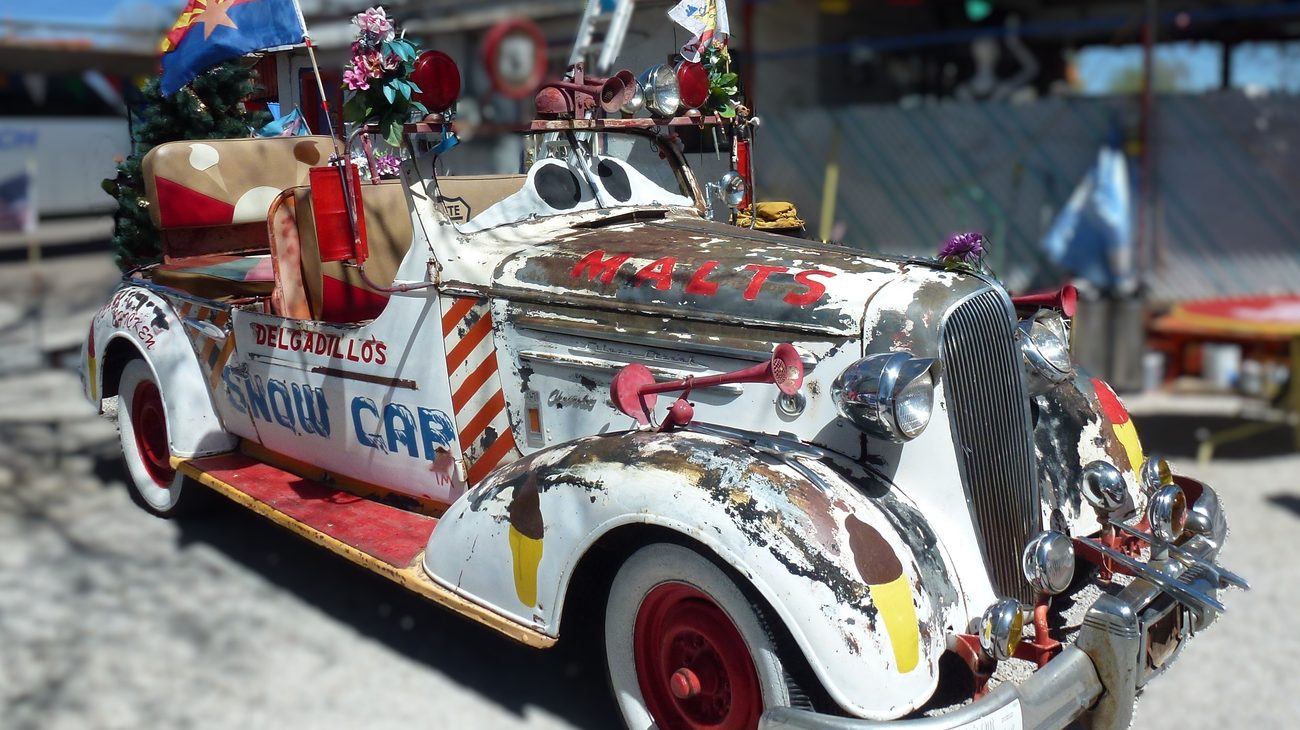 Vintage snow-covered road car and heritage artifacts along historic Route 66 in Seligman