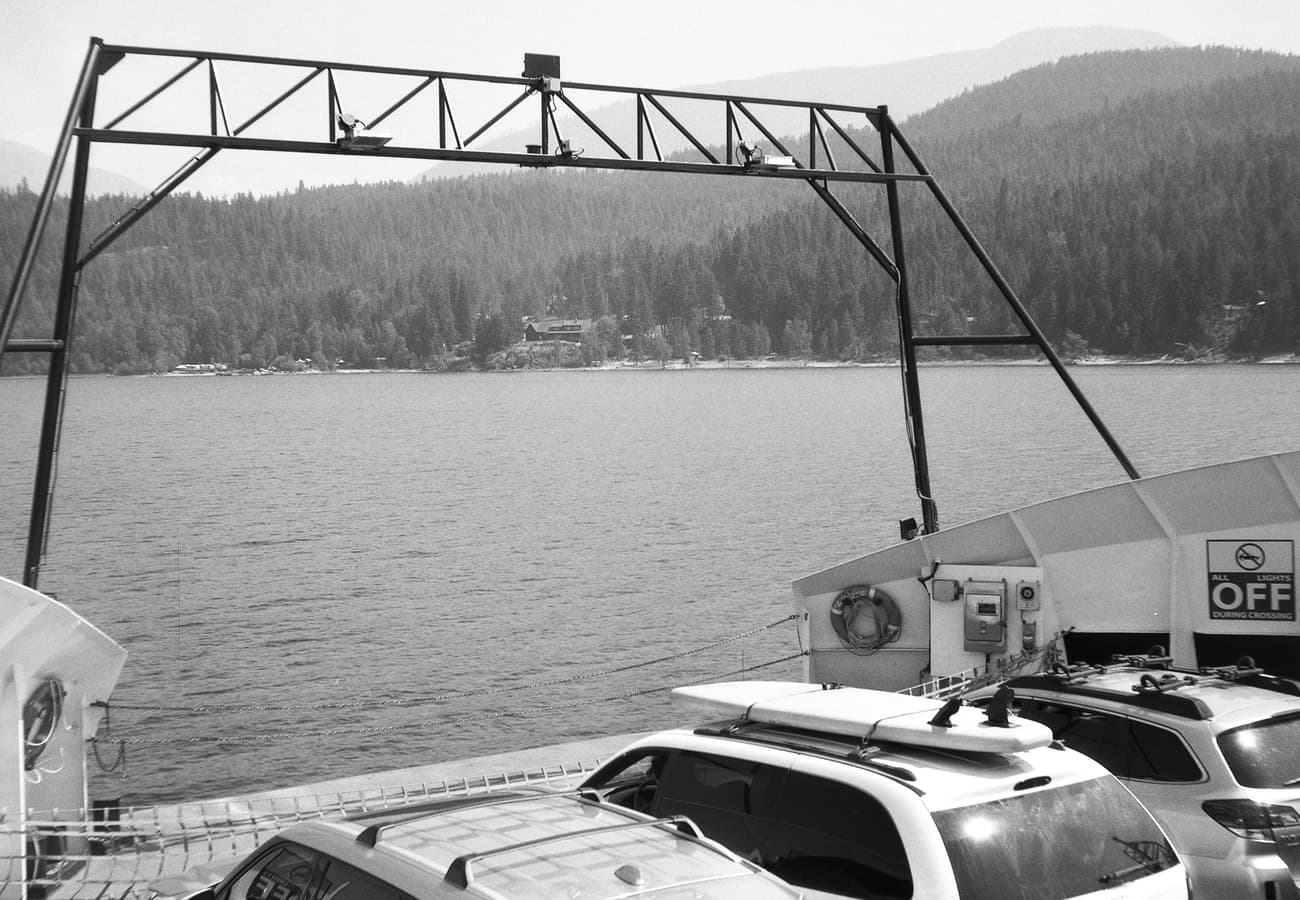 The Kootenay Lake scenic car ferry crossing beneath the rugged Selkirk Mountain range
