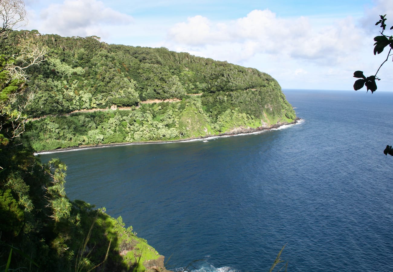Snaking curves through lush rainforest and tropical coastline along the Road to Hana in Maui