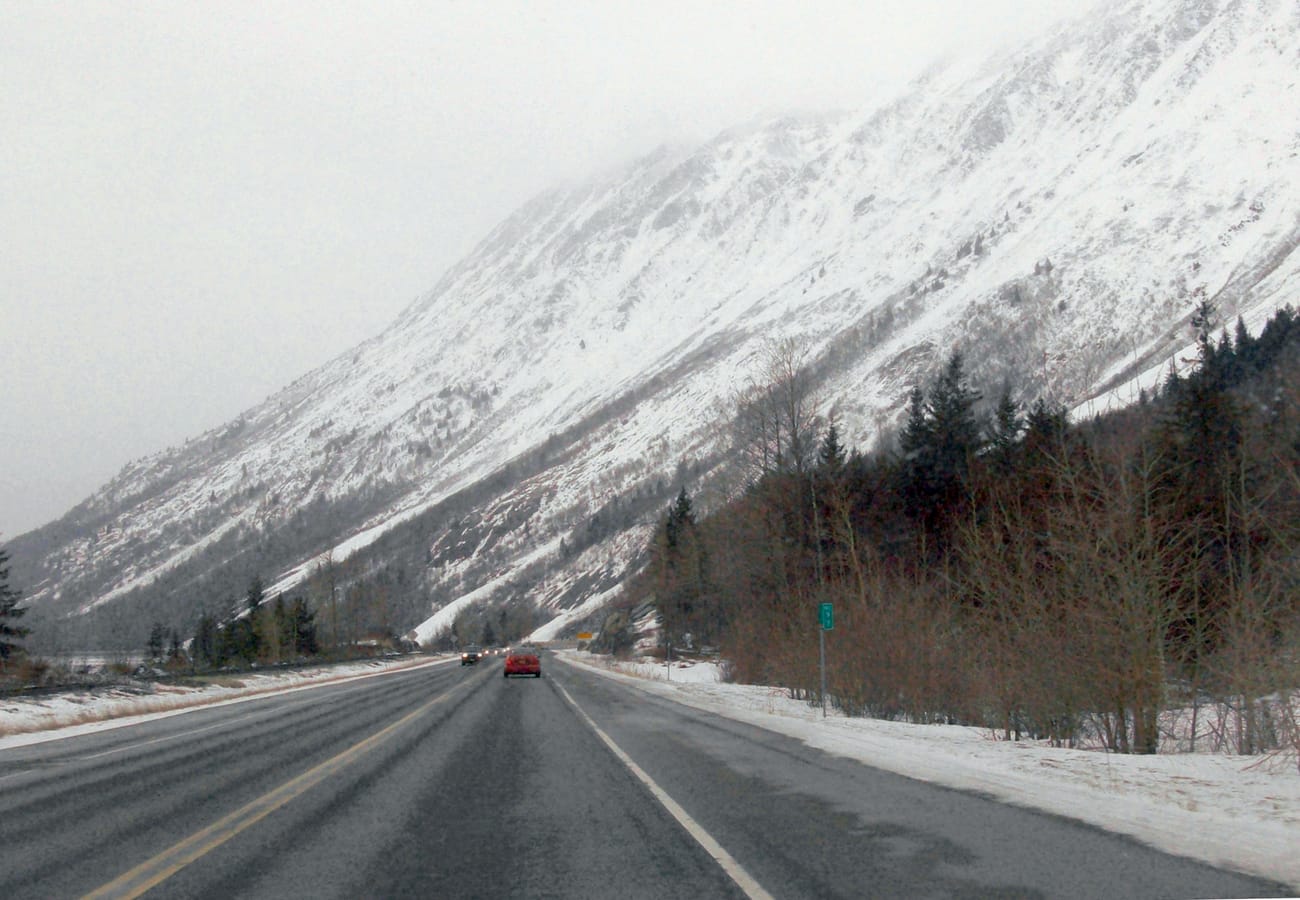Seward Highway running alongside the sparkling waters of Turnagain Arm beneath the Chugach Mountains